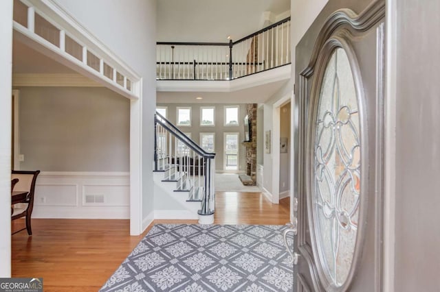 1608 Mulberry Lake Dr, Dacula, GA 30019 - entryway featuring wood finished floors, stairway, a high ceiling, a wainscoted wall, and ornamental molding