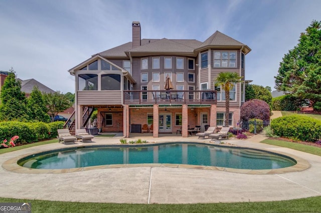 1608 Mulberry Lake Dr, Dacula, GA 30019 - rear view of property featuring a patio area, stairway, a chimney, a sunroom, and an outdoor pool