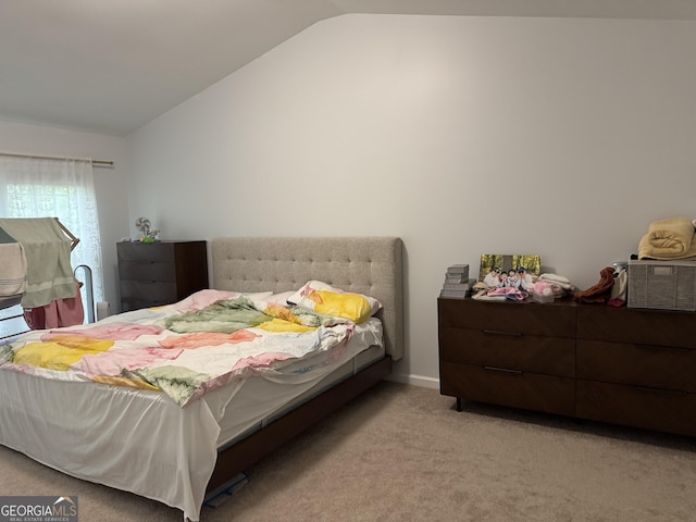 bedroom featuring lofted ceiling and carpet