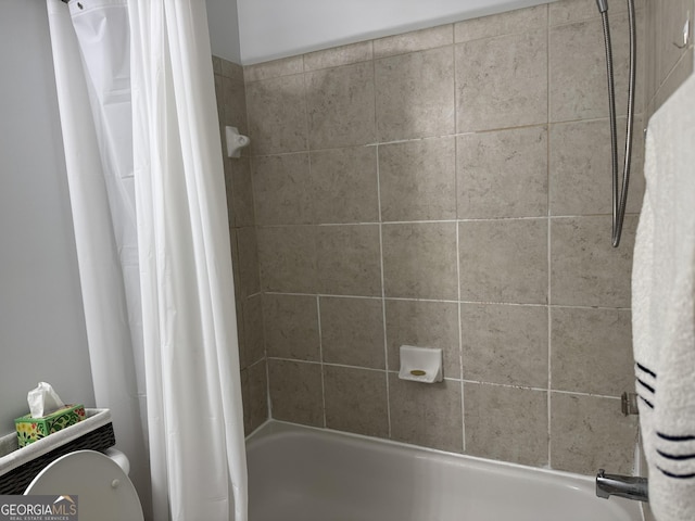bathroom featuring shower / bathtub combination with curtain and toilet
