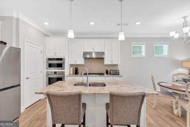 427 Bluffs View Ln, Canton, GA 30114 - kitchen featuring appliances with stainless steel finishes, under cabinet range hood, ornamental molding, decorative backsplash, and a sink