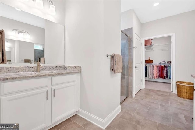 427 Bluffs View Ln, Canton, GA 30114 - bathroom with a stall shower, a spacious closet, vanity, baseboards, and tile patterned flooring