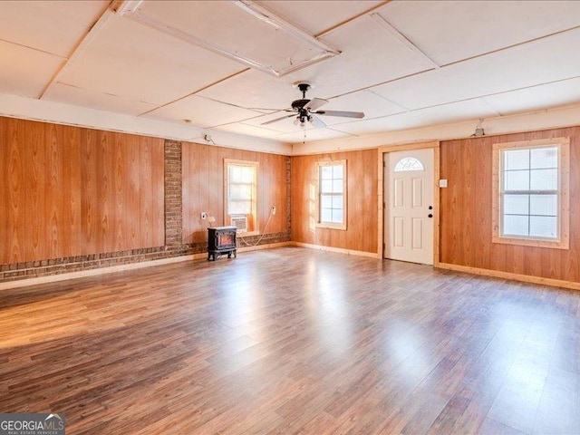 219 Briarwood Dr, Dallas, GA 30132 - unfurnished living room featuring a wood stove, attic access, wood finished floors, wood walls, and a ceiling fan