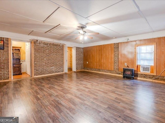 219 Briarwood Dr, Dallas, GA 30132 - unfurnished living room with a wood stove, brick wall, ceiling fan, wood finished floors, and cooling unit