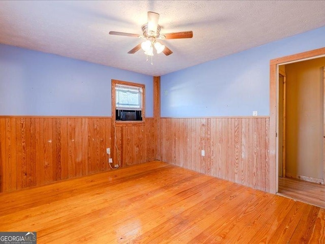 219 Briarwood Dr, Dallas, GA 30132 - unfurnished room with a wainscoted wall, a ceiling fan, wood finished floors, wood walls, and cooling unit