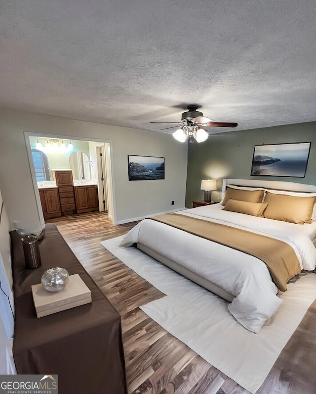 1311 N Brandy Shls, Conyers, GA 30013 - bedroom with wood finished floors, ensuite bath, a textured ceiling, baseboards, and ceiling fan