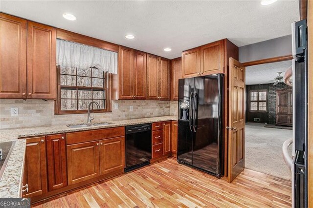 1791 Lake George Dr, Lithia Springs, GA 30122 - kitchen featuring black appliances, a sink, light wood finished floors, light stone countertops, and tasteful backsplash