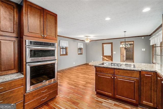 1791 Lake George Dr, Lithia Springs, GA 30122 - kitchen featuring electric stovetop, stainless steel double oven, crown molding, light wood-style floors, and a peninsula