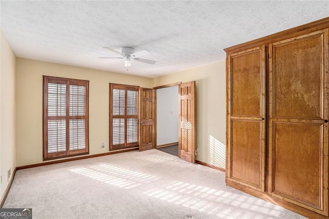 1791 Lake George Dr, Lithia Springs, GA 30122 - unfurnished bedroom with baseboards, a textured ceiling, a ceiling fan, and light carpet