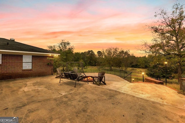 patio terrace at dusk featuring fence