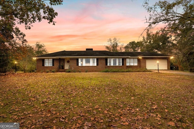 ranch-style house with an attached garage, a lawn, and brick siding