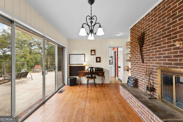 dining room with hardwood / wood-style floors, a chandelier, and a fireplace