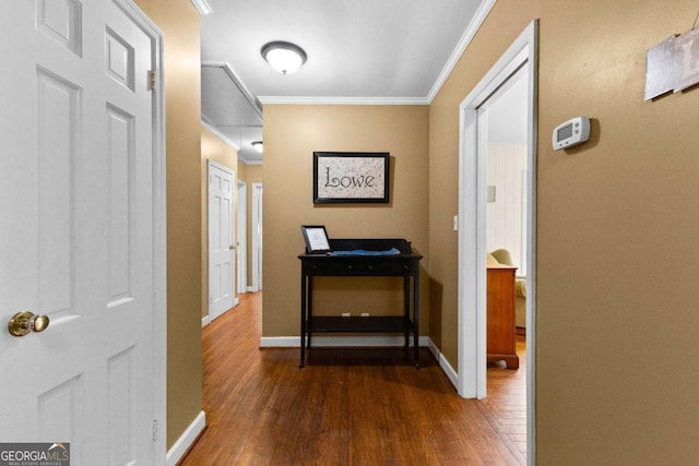 hallway featuring ornamental molding, wood finished floors, and baseboards
