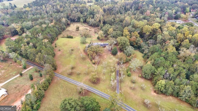 aerial view of property and surrounding area with a heavily wooded area