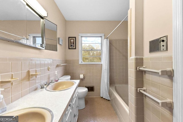 bathroom featuring tile walls, toilet, shower / bathtub combination with curtain, tile patterned flooring, and double vanity