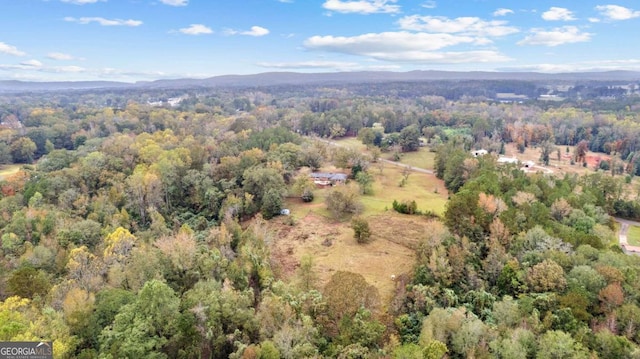 view of property location with a heavily wooded area and mountains