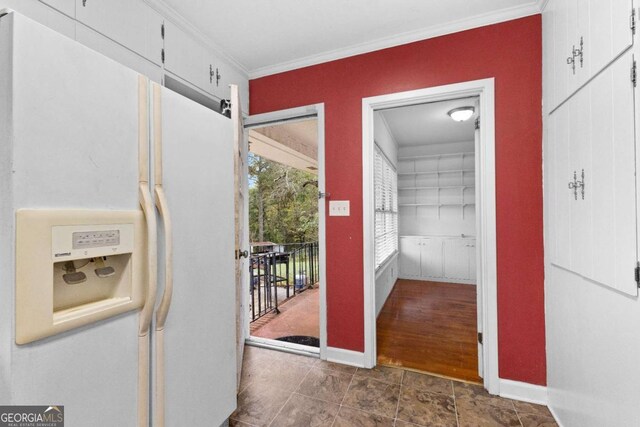 hallway featuring crown molding and baseboards