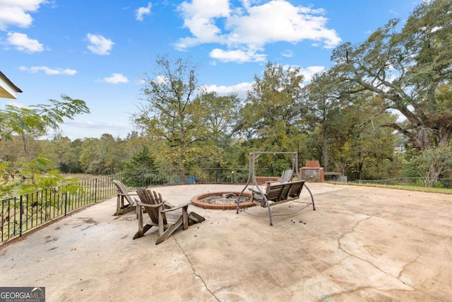 view of patio with fence and a fire pit