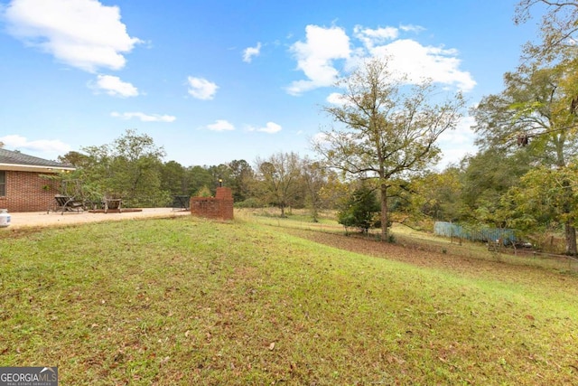 view of green lawn with a patio