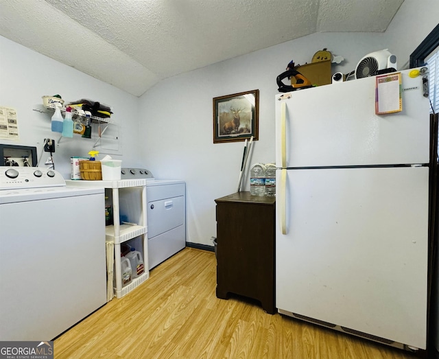 91 Rocky Ln, Cleveland, GA 30528 - kitchen featuring freestanding refrigerator, independent washer and dryer, lofted ceiling, light wood-style floors, and a textured ceiling