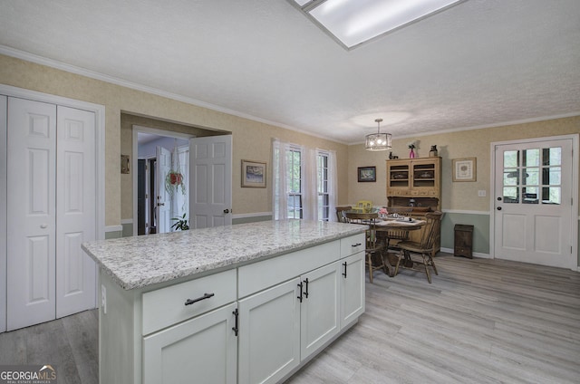 567 Fred Kelley Rd NE, Rome, GA 30161 - kitchen with light wood-type flooring, white cabinetry, a chandelier, ornamental molding, and pendant lighting