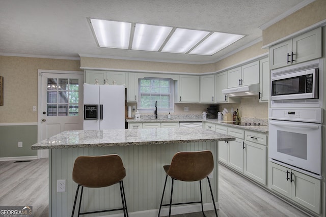567 Fred Kelley Rd NE, Rome, GA 30161 - kitchen with white appliances, light wood-style flooring, a sink, a breakfast bar area, and crown molding