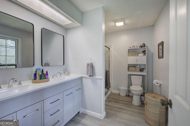567 Fred Kelley Rd NE, Rome, GA 30161 - bathroom featuring wood finished floors, a shower stall, toilet, double vanity, and a textured ceiling