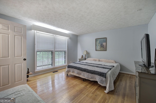 567 Fred Kelley Rd NE, Rome, GA 30161 - bedroom with wood finished floors, a textured ceiling, and baseboards