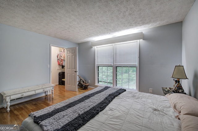 567 Fred Kelley Rd NE, Rome, GA 30161 - bedroom with wood finished floors, baseboards, a textured ceiling, and a spacious closet