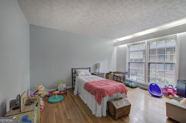 567 Fred Kelley Rd NE, Rome, GA 30161 - bedroom featuring wood finished floors, multiple windows, and a textured ceiling