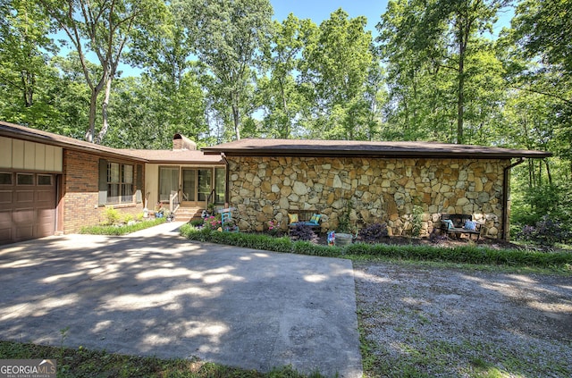 567 Fred Kelley Rd NE, Rome, GA 30161 - rear view of property with stone siding, an attached garage, driveway, a chimney, and brick siding