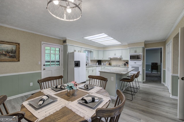 567 Fred Kelley Rd NE, Rome, GA 30161 - dining area featuring a textured ceiling, light wood-type flooring, wainscoting, and crown molding