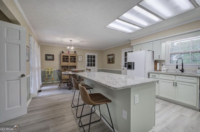 567 Fred Kelley Rd NE, Rome, GA 30161 - kitchen featuring white refrigerator with ice dispenser, a sink, ornamental molding, light wood-style flooring, and a breakfast bar