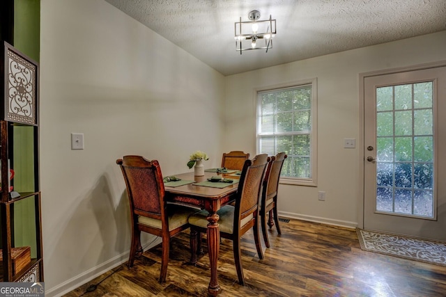 dining room with wood finished floors, baseboards, and a textured ceiling