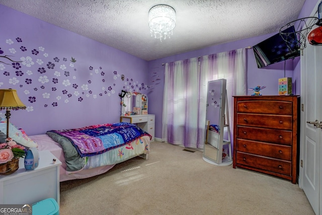 carpeted bedroom with a textured ceiling and a chandelier