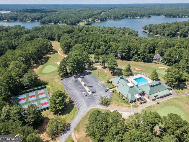 aerial view of a forest, a nearby body of water, and a golf course