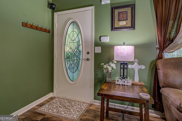 foyer featuring baseboards and wood finished floors