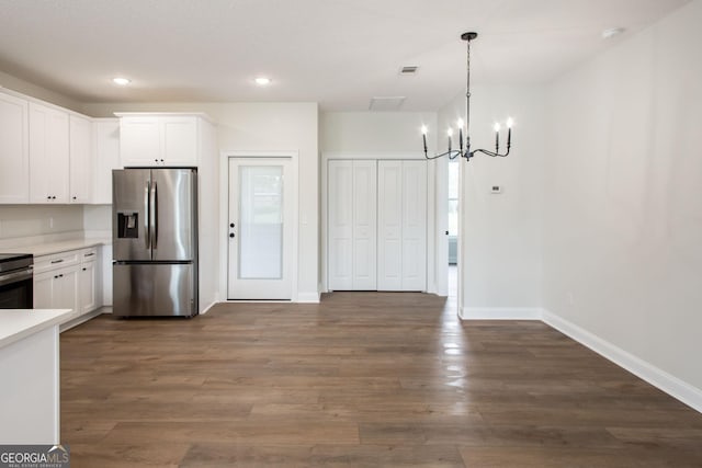 kitchen featuring appliances with stainless steel finishes, a chandelier, baseboards, light countertops, and white cabinetry