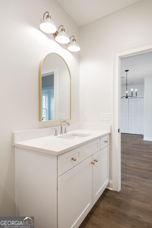 bathroom with wood finished floors, vanity, and a chandelier
