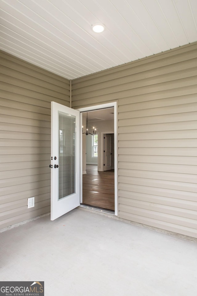 unfurnished sunroom featuring a chandelier and french doors