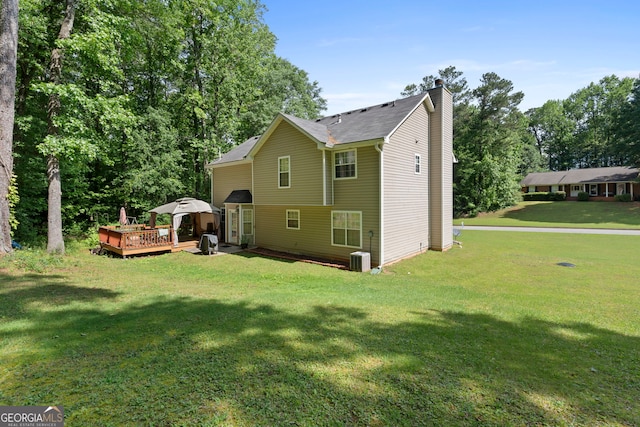 96 Ashtonbrook Dr, Mcdonough, GA 30252 - rear view of house featuring a chimney, a deck, a yard, and central AC