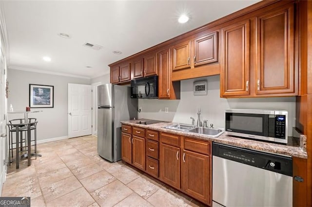 5652 Harbormist Dr, Powder Springs, GA 30127 - kitchen featuring stainless steel appliances, a sink, crown molding, brown cabinetry, and recessed lighting
