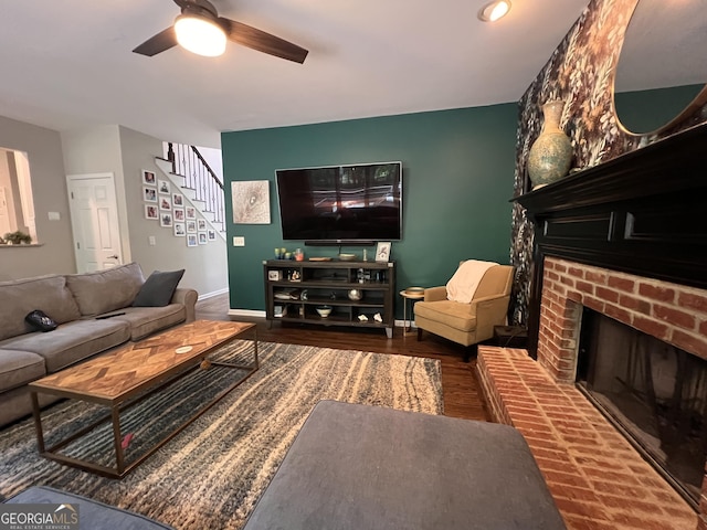5652 Harbormist Dr, Powder Springs, GA 30127 - living room with a brick fireplace, stairway, baseboards, a ceiling fan, and wood finished floors