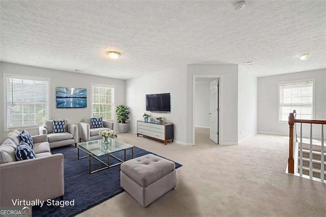 carpeted living room featuring a textured ceiling and baseboards