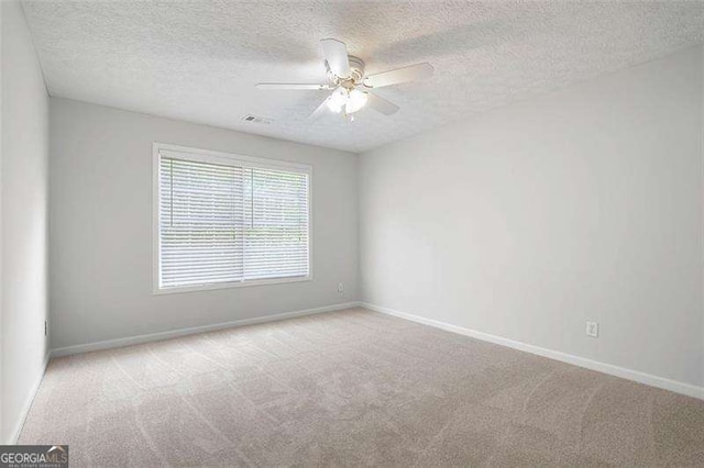 unfurnished room with carpet flooring, baseboards, a textured ceiling, and ceiling fan