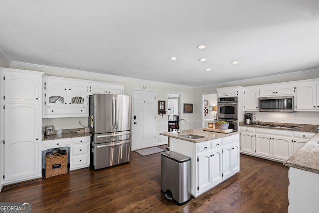 kitchen with appliances with stainless steel finishes, a sink, ornamental molding, white cabinetry, and light stone counters