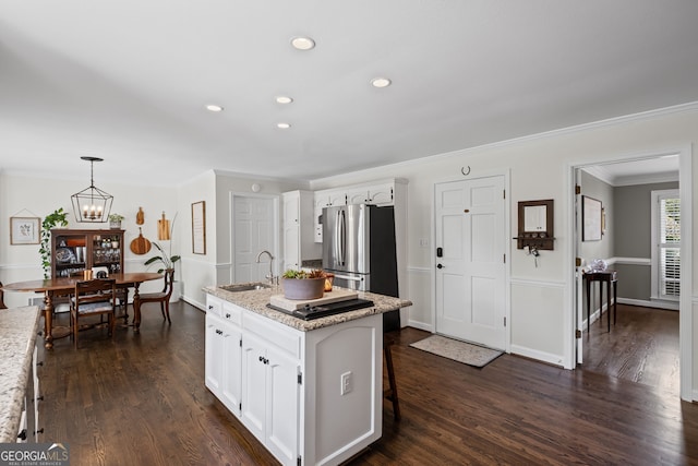 kitchen featuring a sink, freestanding refrigerator, white cabinetry, crown molding, and dark wood-style floors