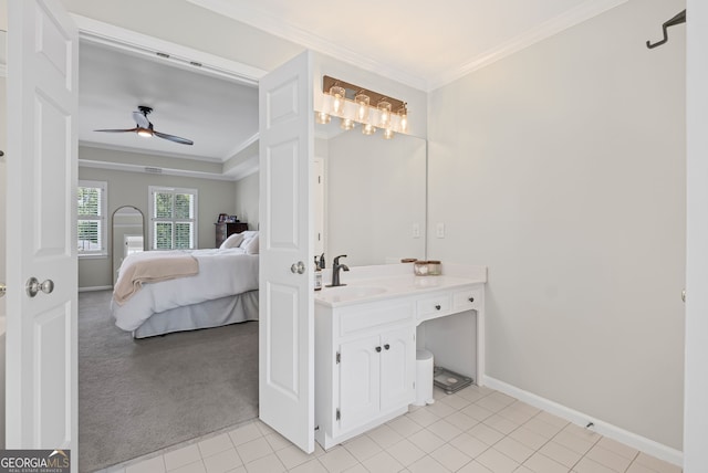 ensuite bathroom with ornamental molding, ceiling fan, baseboards, vanity, and tile patterned floors