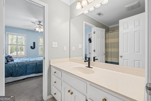 ensuite bathroom with ornamental molding, vanity, and a ceiling fan