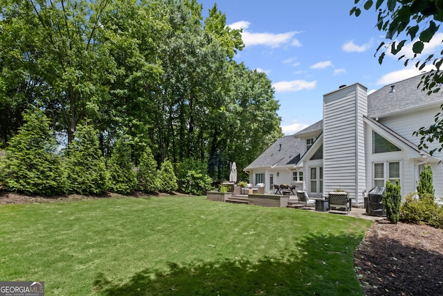 view of green lawn with an outdoor living space and a wooden deck